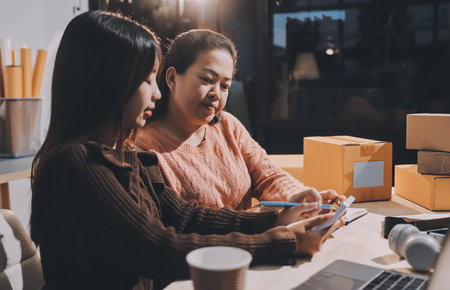 Asian woman selling clothes on camera live broadcast on social network at home. Online selling clothes on social media. Blogger woman influencer, SME retail store owner.の写真素材