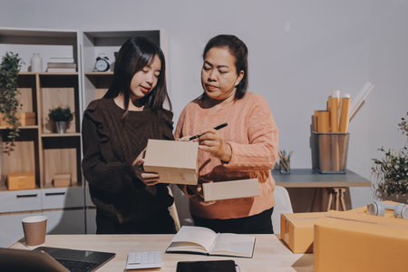 Asian woman selling clothes on camera live broadcast on social network at home. Online selling clothes on social media. Blogger woman influencer, SME retail store owner.の写真素材