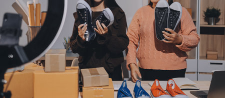 Asian woman describe selling clothes on camera live broadcast on social network at home, Online selling clothes on social media. Blogger woman influencer, SME retail store owner.の写真素材