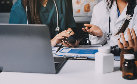 Group of doctors attending seminar in hospital lecture hall with senior physician giving medical presentation and professional training session on healthcare practicesの写真素材