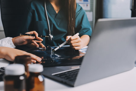 Group of doctors attending seminar in hospital lecture hall with senior physician giving medical presentation and professional training session on healthcare practicesの写真素材