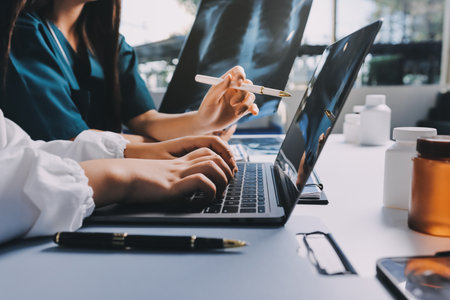 Group of doctors attending seminar in hospital lecture hall with senior physician giving medical presentation and professional training session on healthcare practicesの写真素材