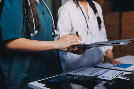 Group of doctors attending seminar in hospital lecture hall with senior physician giving medical presentation and professional training session on healthcare practicesの写真素材