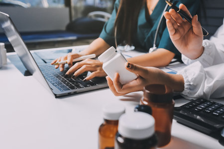 Group of doctors attending seminar in hospital lecture hall with senior physician giving medical presentation and professional training session on healthcare practicesの写真素材