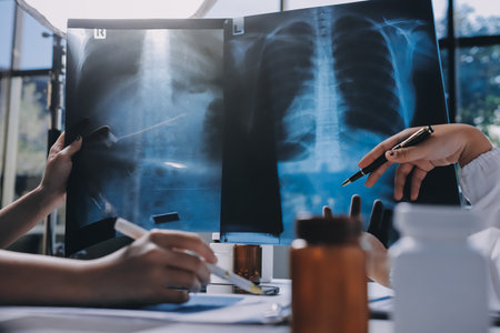 Group of doctors attending seminar in hospital lecture hall with senior physician giving medical presentation and professional training session on healthcare practicesの写真素材