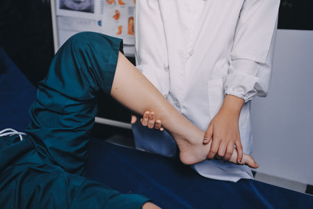 Rehabilitation therapy Professional male physiotherapists working in rehabilitation centers while treating male patients with leg and muscle pain.の写真素材