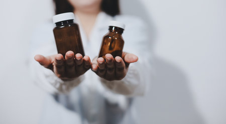 The pharmacist or doctor holding medication or medicine for treatment. Anti biotic pill in the vial.