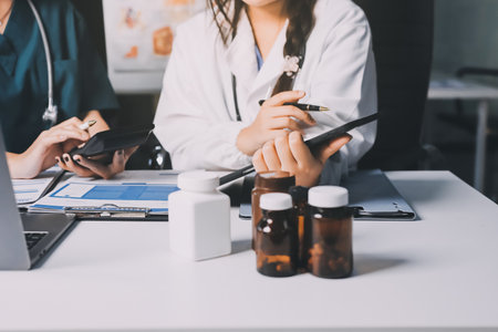 Group of doctors attending seminar in hospital lecture hall with senior physician giving medical presentation and professional training session on healthcare practicesの写真素材