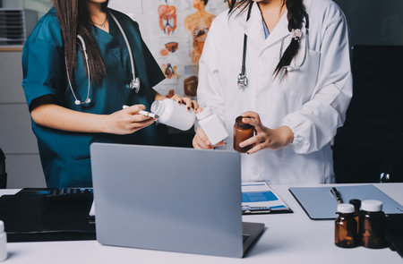 Group of doctors attending seminar in hospital lecture hall with senior physician giving medical presentation and professional training session on healthcare practicesの写真素材