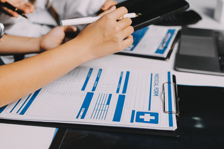 Group of doctors attending seminar in hospital lecture hall with senior physician giving medical presentation and professional training session on healthcare practicesの写真素材