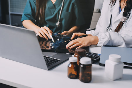 Group of doctors attending seminar in hospital lecture hall with senior physician giving medical presentation and professional training session on healthcare practicesの写真素材