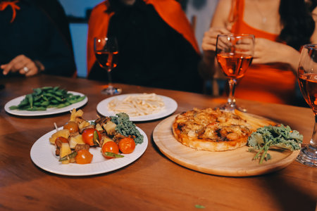 Joyful office Halloween party with coworkers in costumes, celebrating with drinks and laughter, fostering teamwork and festive spiritの写真素材