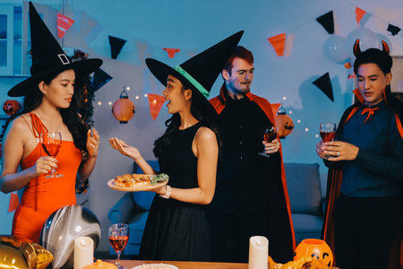 Joyful office Halloween party with coworkers in costumes, celebrating with drinks and laughter, fostering teamwork and festive spiritの写真素材