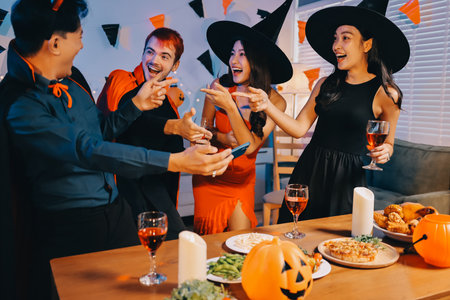 Joyful office Halloween party with coworkers in costumes, celebrating with drinks and laughter, fostering teamwork and festive spiritの写真素材