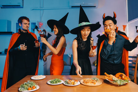 Joyful Halloween party with coworkers in costumes, celebrating with drinks and laughter, fostering teamwork and festive spiritの写真素材