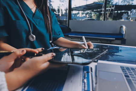 Group of doctors attending seminar in hospital lecture hall with senior physician giving medical presentation and professional training session on healthcare practicesの写真素材