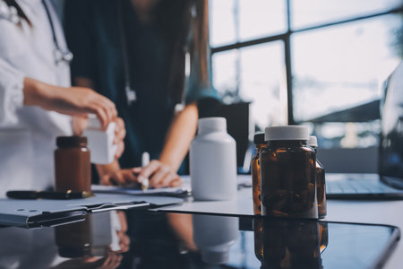 Group of doctors attending seminar in hospital lecture hall with senior physician giving medical presentation and professional training session on healthcare practicesの写真素材