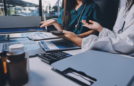 Group of doctors attending seminar in hospital lecture hall with senior physician giving medical presentation and professional training session on healthcare practicesの写真素材