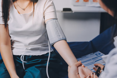 Nurse measuring blood pressure of elderly woman at table, closeup. Assisting senior generationの写真素材