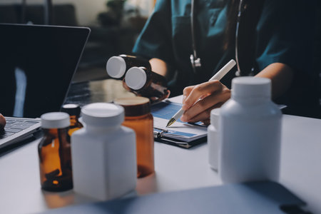 Group of doctors attending seminar in hospital lecture hall with senior physician giving medical presentation and professional training session on healthcare practicesの写真素材