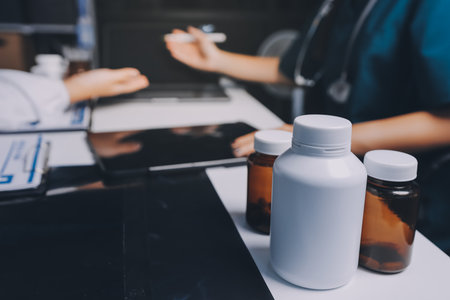 Group of doctors attending seminar in hospital lecture hall with senior physician giving medical presentation and professional training session on healthcare practicesの写真素材