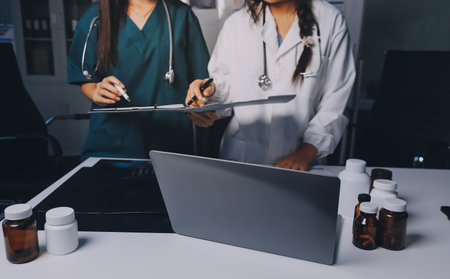 Group of doctors attending seminar in hospital lecture hall with senior physician giving medical presentation and professional training session on healthcare practicesの写真素材