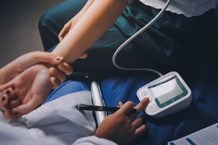 Nurse measuring blood pressure of elderly woman at table, closeup. Assisting senior generationの写真素材