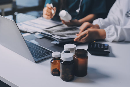 Group of doctors attending seminar in hospital lecture hall with senior physician giving medical presentation and professional training session on healthcare practicesの写真素材