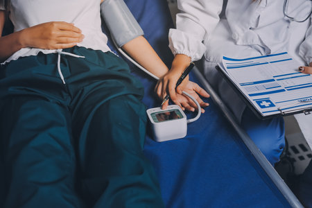 Nurse measuring blood pressure of elderly woman at table, closeup. Assisting senior generationの写真素材