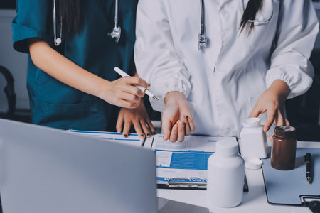 Group of doctors attending seminar in hospital lecture hall with senior physician giving medical presentation and professional training session on healthcare practicesの写真素材