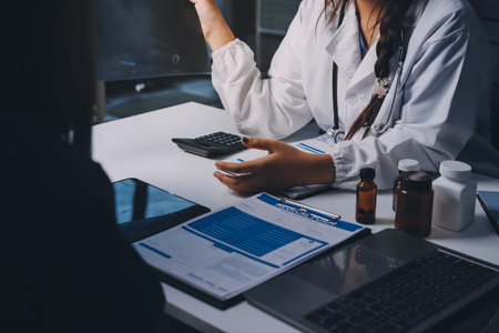 Group of doctors attending seminar in hospital lecture hall with senior physician giving medical presentation and professional training session on healthcare practicesの写真素材