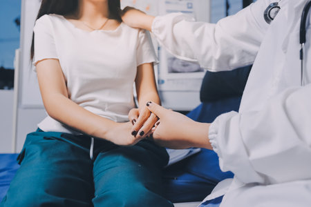 Doctor giving hope. Close up shot of young female physician leaning forward to smiling elderly lady patient holding her hand in palms. Woman caretaker in white coat supporting encouraging old personの写真素材