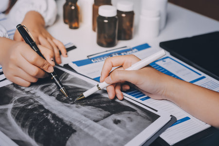 Group of doctors attending seminar in hospital lecture hall with senior physician giving medical presentation and professional training session on healthcare practicesの写真素材