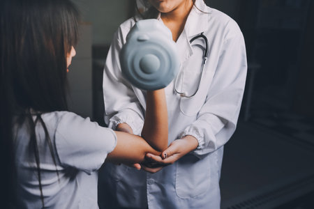 old woman training with physiotherapist using dumbbells at home therapist assisting senior woman with exercises in nursing home elderly patient using dumbbells with outstretched arms no logos no branの写真素材
