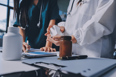 Group of doctors attending seminar in hospital lecture hall with senior physician giving medical presentation and professional training session on healthcare practicesの写真素材