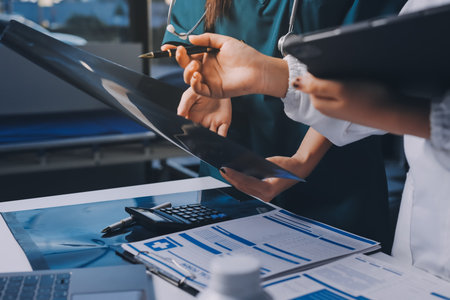 Group of doctors attending seminar in hospital lecture hall with senior physician giving medical presentation and professional training session on healthcare practicesの写真素材