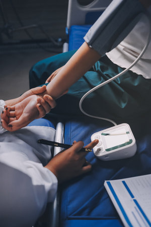 Nurse measuring blood pressure of elderly woman at table, closeup. Assisting senior generationの写真素材