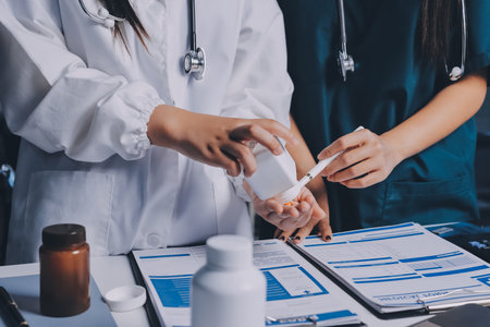 Group of doctors attending seminar in hospital lecture hall with senior physician giving medical presentation and professional training session on healthcare practicesの写真素材