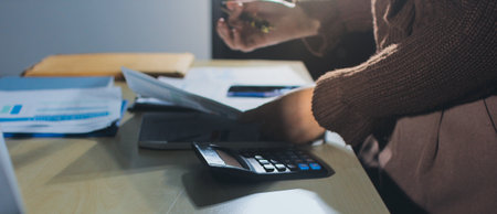 Close-up of businessman's hands making notes, mobiles, chart, desk, officeの写真素材