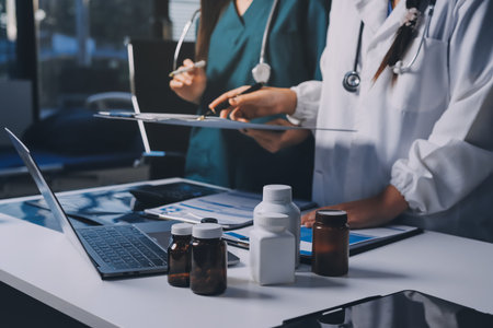 Group of doctors attending seminar in hospital lecture hall with senior physician giving medical presentation and professional training session on healthcare practicesの写真素材