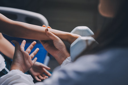 old woman training with physiotherapist using dumbbells at home therapist assisting senior woman with exercises in nursing home elderly patient using dumbbells with outstretched arms no logos noの写真素材