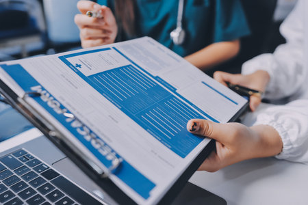 Group of doctors attending seminar in hospital lecture hall with senior physician giving medical presentation and professional training session on healthcare practicesの写真素材