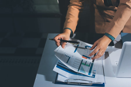 Close-up of businessman's hands making notes, chart, desk, officeの写真素材