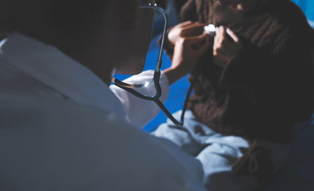 Homecare nursing service and elderly people cardiology healthcare. Close up of young hispanic female doctor nurse check mature caucasian man patient heartbeat using stethoscope during visitの写真素材