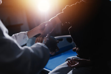 Old woman training with physiotherapist using dumbbells at home. Therapist assisting senior woman with exercises in nursing home. Elderly patient using dumbbells with outstretched arms.の写真素材