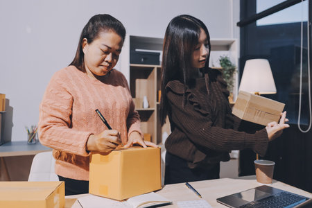 Asian woman selling clothes on camera live broadcast on social network at home. Online selling clothes on social media. Blogger woman influencer, SME retail store owner.の写真素材