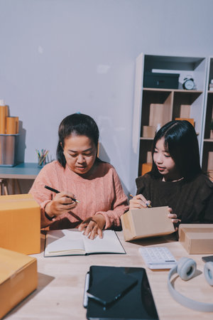 Asian woman selling clothes on camera live broadcast on social network at home, Online selling clothes on social media. Blogger woman influencer, SME retail store owner.の写真素材