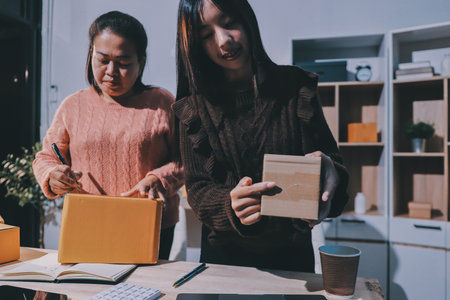 Asian woman describe selling clothes on camera live broadcast on social network at home, Online selling clothes on social media. Blogger woman influencer, retail store owner.の写真素材