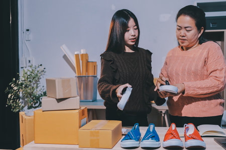 Asian woman describe selling clothes on camera live broadcast on social network at home, Online selling clothes on social media. Blogger woman influencer, SME retail store owner.の写真素材