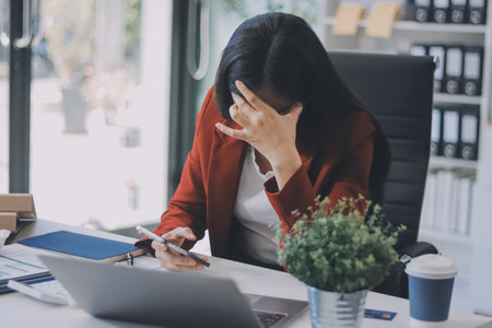 tired business woman sleepy and bored from sitting at a desk for a long timeの写真素材